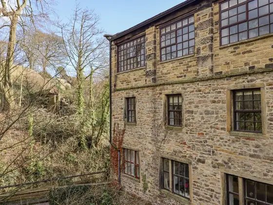 The mill seen across the beck through bare winter trees